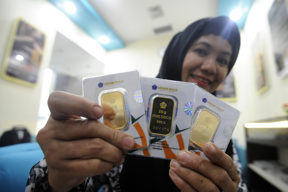 A customer shows gold bars purchased from an Antam outlet in Jakarta. (Antara Photo)
