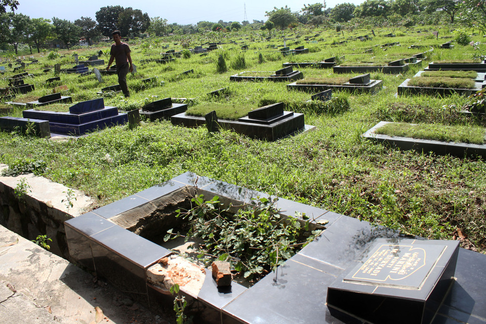 A cemetery guard walks through the Magunjaya Public Cemetery in South Tambun, Bekasi, West Java, on Thursday (08/12). The cemetery has been sealed by a family who claims to have rights to the land. (Antara Photo/Risky Andrianto)

