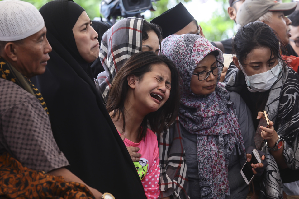 Zanette Kalila, center, in tears during her father's and sisters' funeral in Jakarta on Wednesday. (Antara Photo/Muhammad Adimaja)