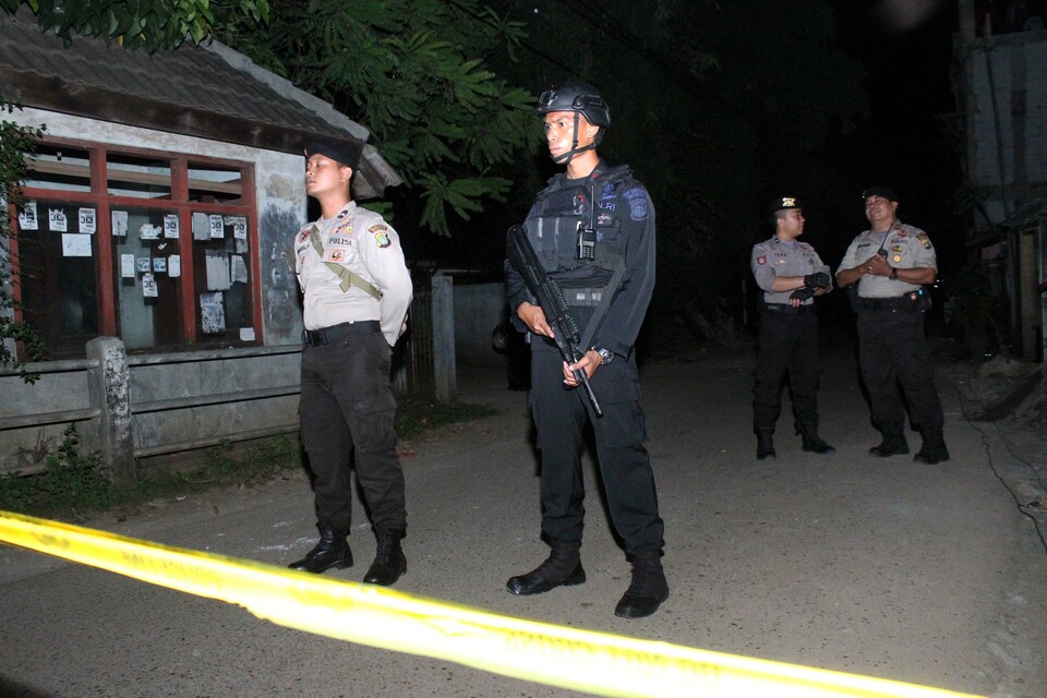 Police officers stand guard during a raid on a terrorist hideout. (Antara Photo/Risky Andrianto)