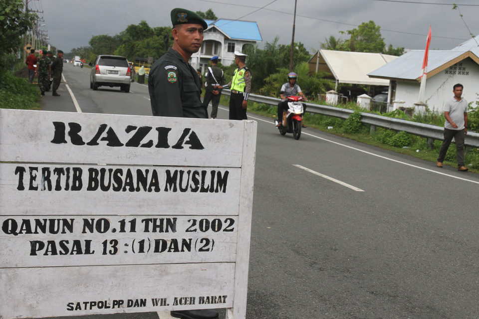 Islamic police, known as Wilayatul Hisbah, and municipal police in Johan Pahlawan, West Aceh, Aceh, on Wednesday (21/12) check the residents' conformity with the Islamic dress code enforced by local authorities. (Antara Photo/Syifa Yulinnas)