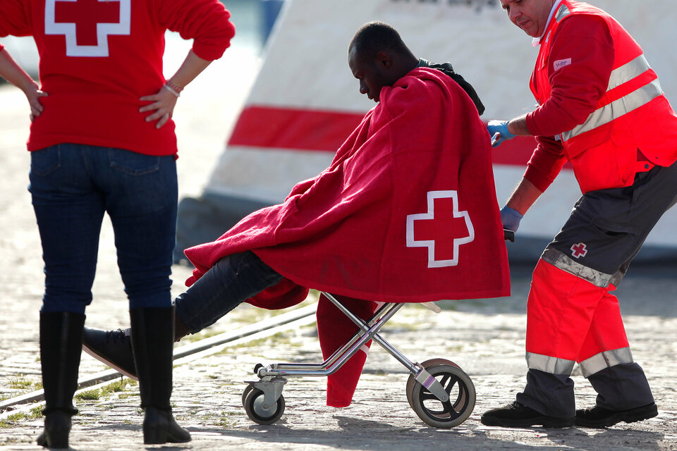 A migrant, who is part of a group intercepted aboard a dinghy off the coast in the Mediterranean sea, is pushed on a wheelchair by a member of Spanish Red Cross after arriving on a rescue boat at a port in Malaga, southern Spain, January 1, 2017. (Reuters Photo/Jon Nazca)