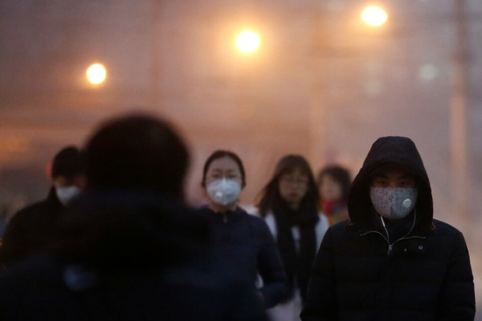 People wear face masks as they cross a street on a polluted day in Beijing, China January 4, 2017.  (Reuters Photo/Thomas Peter)