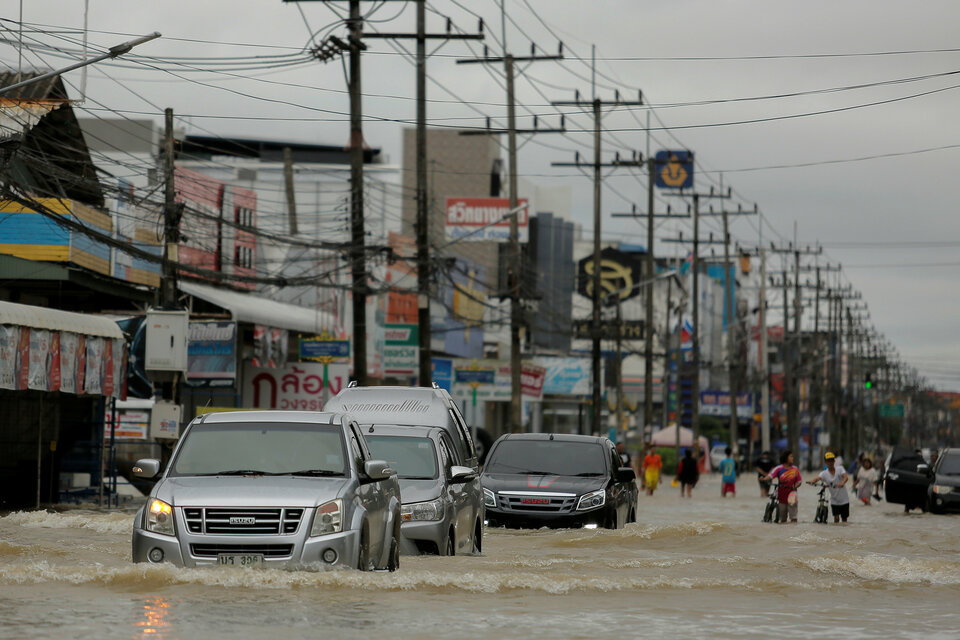 Cars drive through a flooded street at Muang district in Nakhon Si Thammarat province, southern Thailand.  (Reuters Photo/Wirittipon Withandetsit)