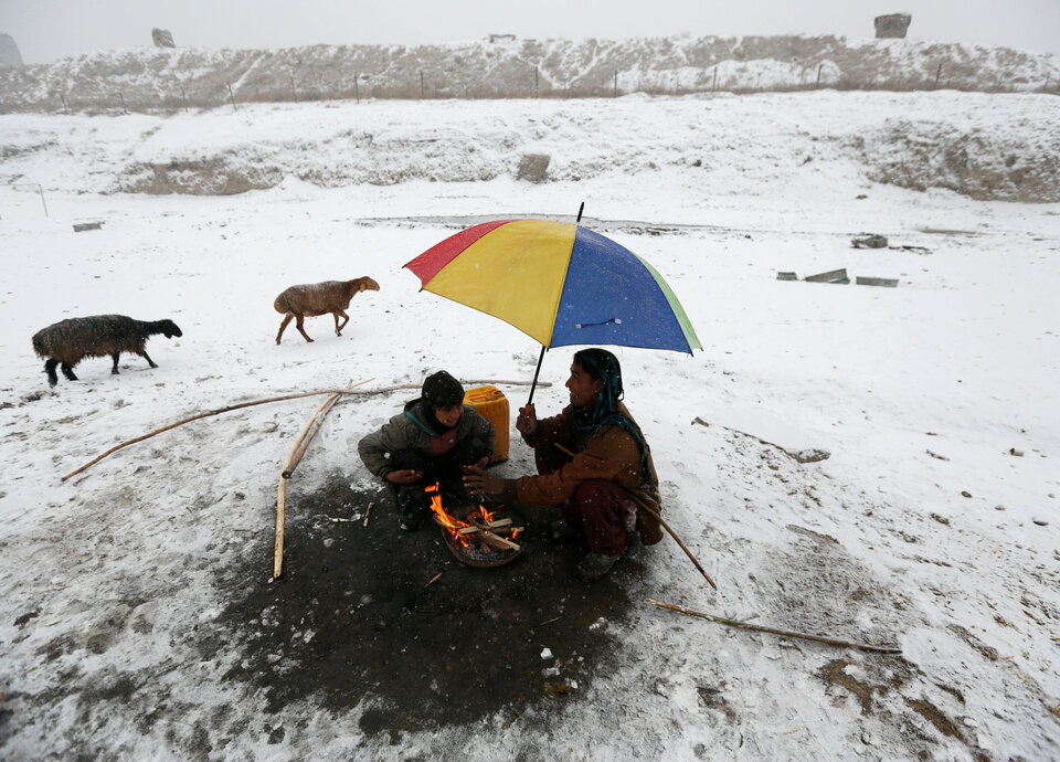 Afghan men warm themselves by a fire on a snowy day in Kabul, Afghanistan, on Jan. 14. (Reuters Photo/Mohammad Ismail)