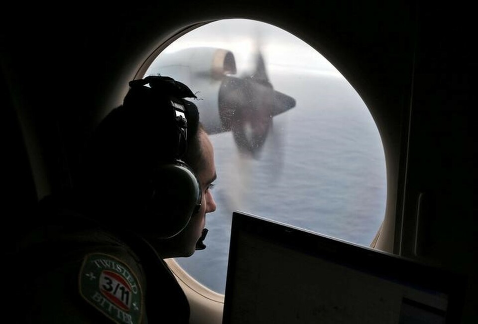 Flight officer Rayan Gharazeddine looks out of a Royal Australian Air Force AP-3C Orion as it flies over the southern Indian Ocean during the search for missing Malaysian Airlines flight MH370 on March 22, 2014. (Reuters Photo/Rob Griffith)