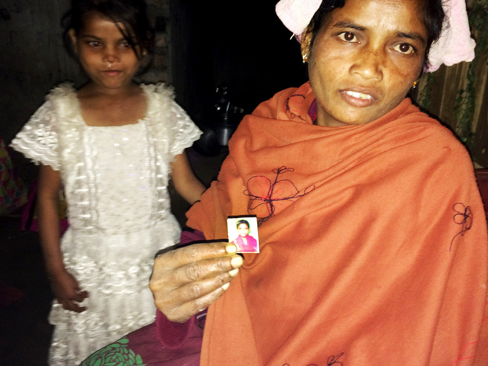 Rukmani Naik poses with a picture of her 14-year-old daughter who left their home in the Diana Tea Estate in West Bengal, India, to work in another city.  (Reuters Photo)