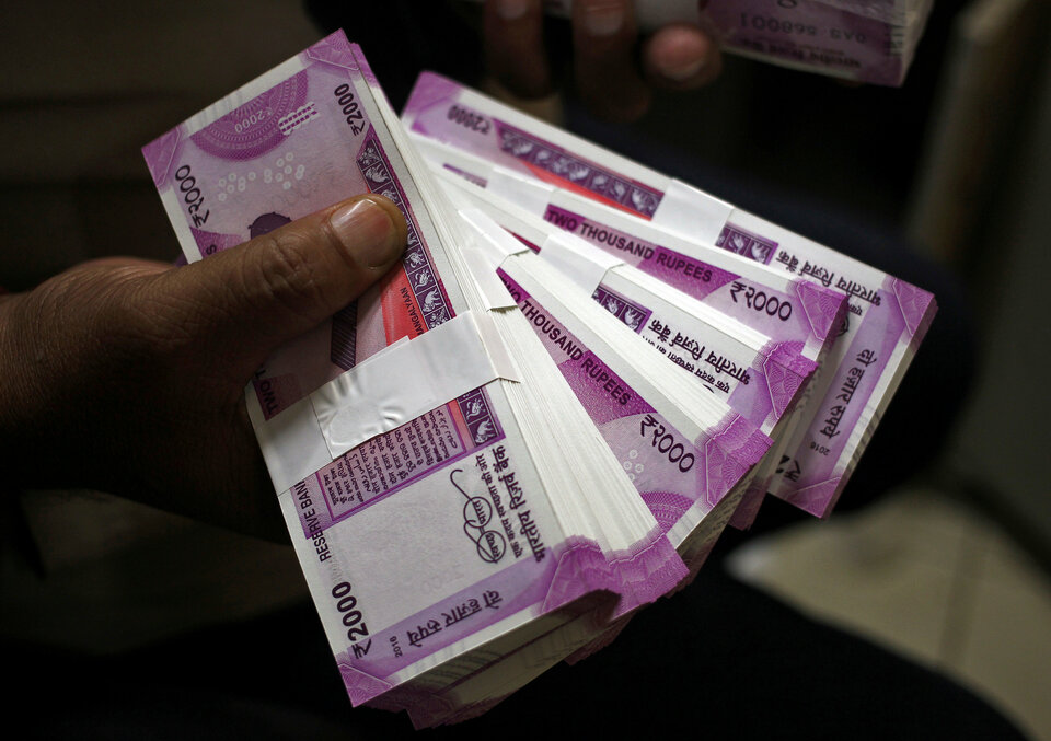 A cashier displays the new 2000 Indian rupee banknotes inside a bank in Jammu, November 15, 2016. (Reuters Photo/Mukesh Gupta)