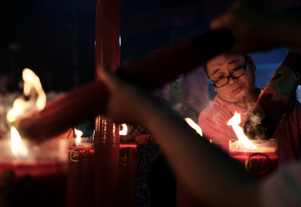 A man lights up incense at Dharma Sakti temple before praying during the Chinese Lunar New Year, in Jakarta, Indonesia January 28, 2017. Reuters Photo/Beawiharta