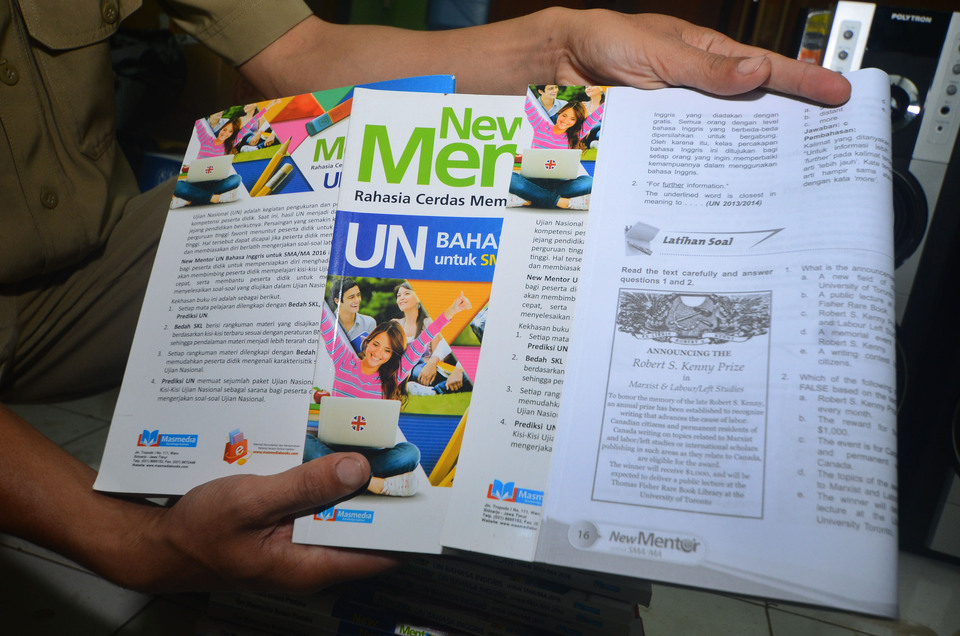 A teacher at SMA Negeri 1 Kawali in Ciamis, West Java, displays national examination course material in English language studies that contain a communist hammer-and-sickle symbol, which is banned in Indonesia. The 170-page book titled 'New Mentor: Secrets of Smart Dissecting National Examination English for High Schools 2016' is published by Masmedia Buana Pustaka. (Antara Photo/Adeng Bustomi) 