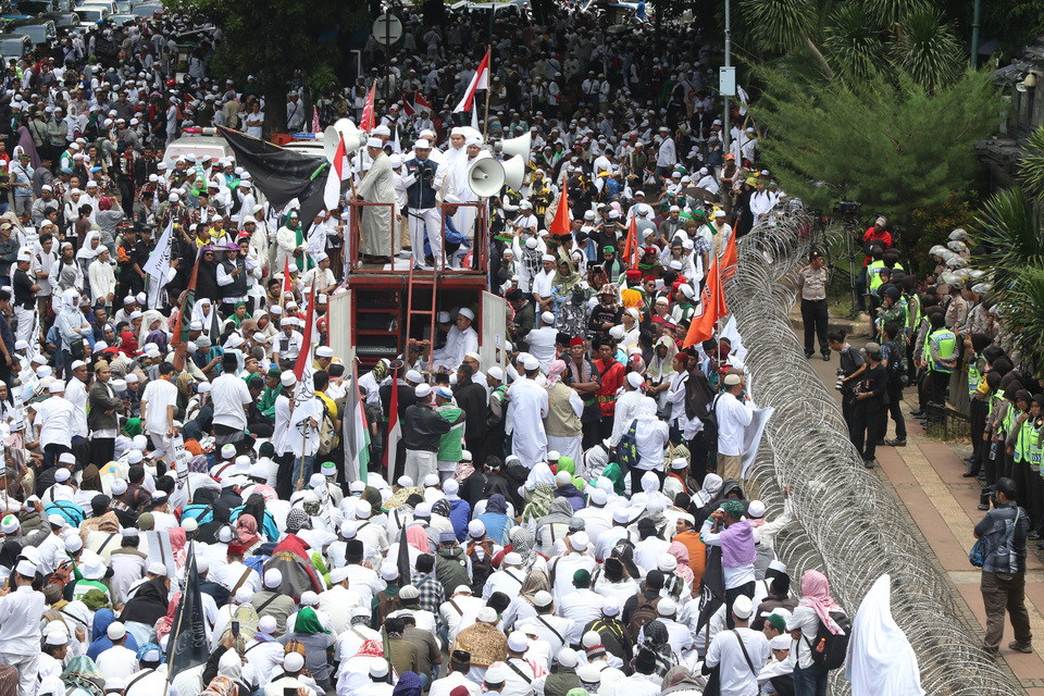 Members of the Islamic Defenders Front (FPI) demonstrating in front of the Jakarta Police headquarters on Monday (23/01) while their leader Rizieq Shihab is undergoing questioning in a defamation probe. (Antara Photo/Reno Esnir)