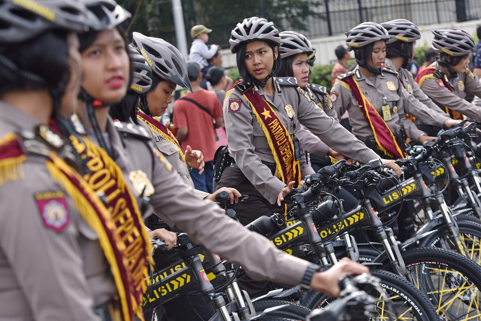 Policewomen prepare to conduct patrols on bicycles during car-free day at the Hotel Indonesia traffic circle in Central Jakarta on Sunday (15/01). (Antara Photo/Wahyu Putro A)