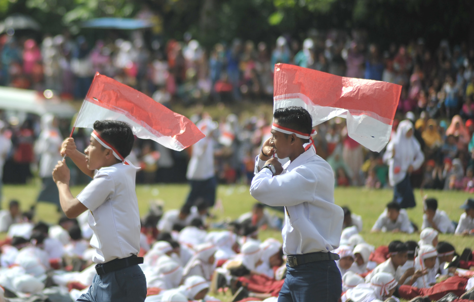 Students carry flags during a ceremony in Situjuah Batua, Limapuluhkota, West Sumatra, on Sunday (15/01). More than 1,000 students from elementary and high schools participated in the ceremony to commemorate Battle of Situjuah on Jan. 15, 1949 when Dutch colonial forces attacked and killed several Indonesian freedom fighters. (Antara Photo/Iggoy el Fitra)