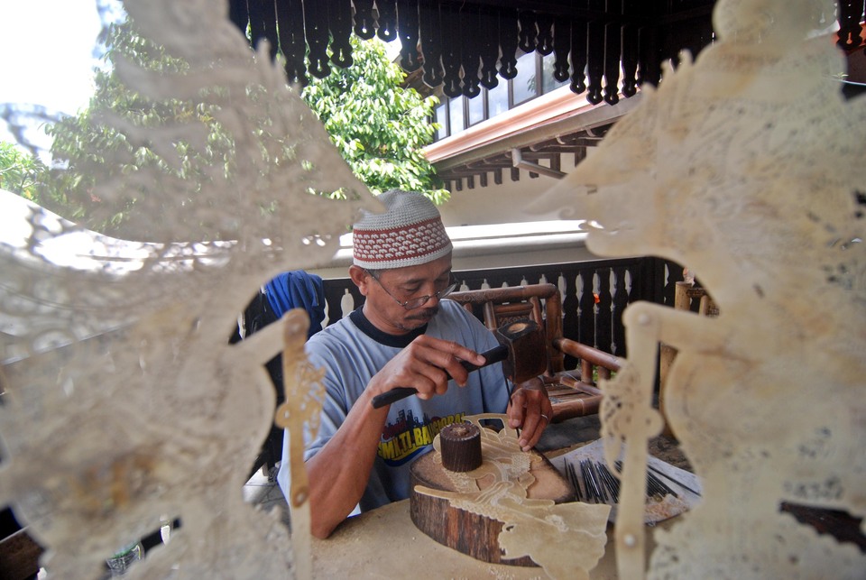 A craftsman making wayang kulit, or shadow puppets, from buffalo skin in Yogyakarta on Saturday (07/01). Data from the Ministry of Industry shows that 165 983 new small and medium enterprises were established in Indonesia in 2016, creating as many as 350,000 jobs, with 23 percent of them employed in the craft sector. (Antara Photo/Pradana Aditya Putra)