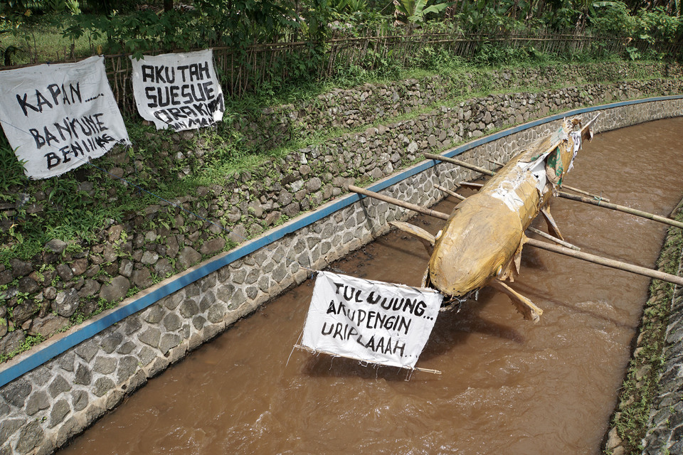 An artificial fish and posters have been mounted in a protest against the geothermal power plant development on the Krukut River in Karangtengah, Banyumas, Central Java, on Monday (16/01). Karangtengah village residents fear the plant will disrupt their peace and pollute their fish ponds. (Antara Photo/Idhad Zakaria)