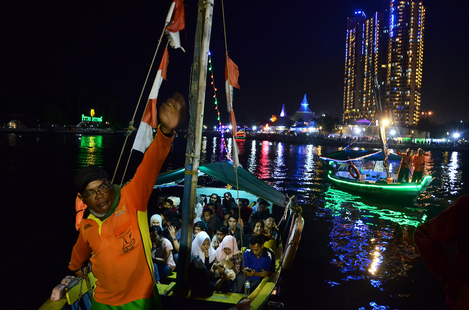 People ride in boats in Ancol during New Year's Eve celebrations. (Antara Photo/Fakhri Hermansyah)