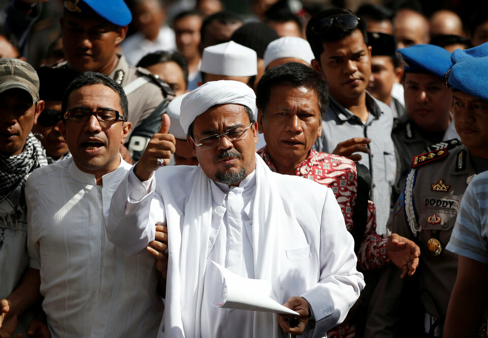 Rizieq Shihab, center, is on the run from the police after pornography charges. (Reuters Photo/Darren Whiteside)