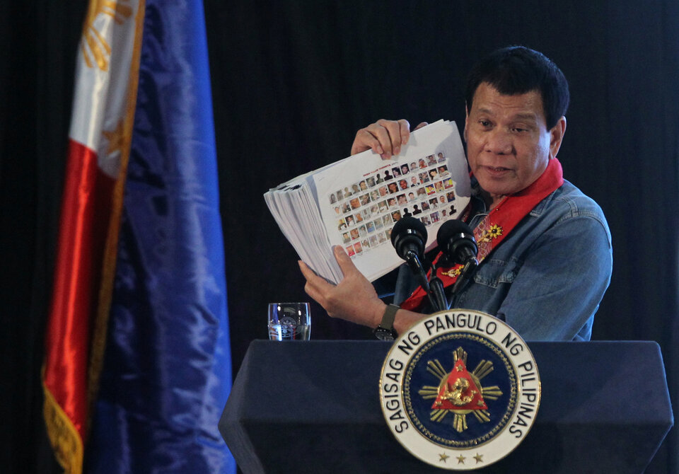 Philippine President Rodrigo Duterte holds a compilation of pictures of people involved in drugs, as he speaks during a meeting in Davao city in southern Philippines February 2, 2017. (Reuters Photo/Lean Daval Jr)