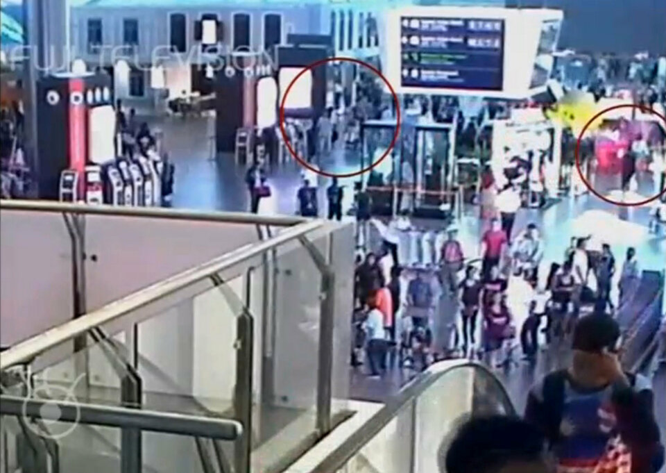 A still image from a CCTV footage appears to show a woman in a white shirt, circled in red on right, walking away after accosting a man purported to be Kim Jong-nam, circled in red on left, at Kuala Lumpur International Airport in Malaysia on Feb. 13, 2017. (Reuters Photo/Fuji TV)