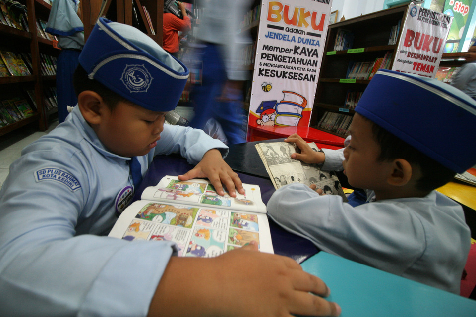 Schoolchildren read at a library in Kediri, East Java, on Thursday (23/02). (Antara Photo/Prasetia Fauzani)