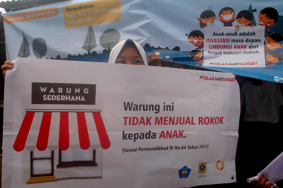 Students from SMP 1 Bojong Gede take down cigarette advertisements and replace them with public service announcements at local shops near their school in Bojong Gede, Bogor Regency, West Java. (ANTARAFOTO/Yulius Satria Wijaya)