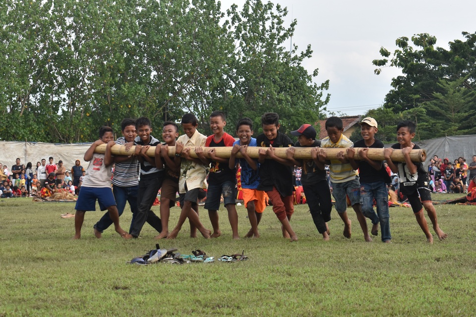 Children try to hold a large bamboo stick while playing bambu gila (crazy bamboo), in Madiun, East Java on Sunday (05/02). The game is a mystical ritual where a group of strong men struggle to control a piece of bamboo from moving around like crazy as if it were possessed by the supernatural. The origins of the ritual are unknown, but it is believed the ancient ritual was once used to induce a fearless fighting mentality before going to war. Today, this unique tradition has been reduced to a popular tourist attraction. (Antara Photo/Siswowidodo)