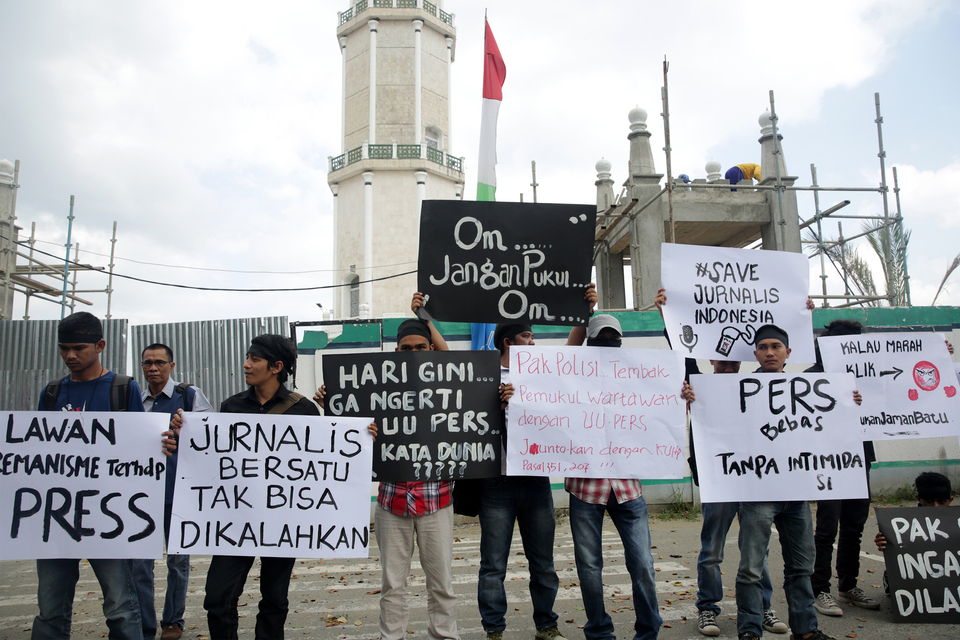 Journalists from various media outlets carry placards during a solidarity rally in front of the Baiturrahman Grand Mosque in Banda Aceh on Monday (13/02). The journalists requested the authorities to thoroughly investigate alleged acts of violence against three television journalists during Saturday's 112 rally at the Istiqlal Mosque in Jakarta. (Antara Photo/Irwansyah Putra)