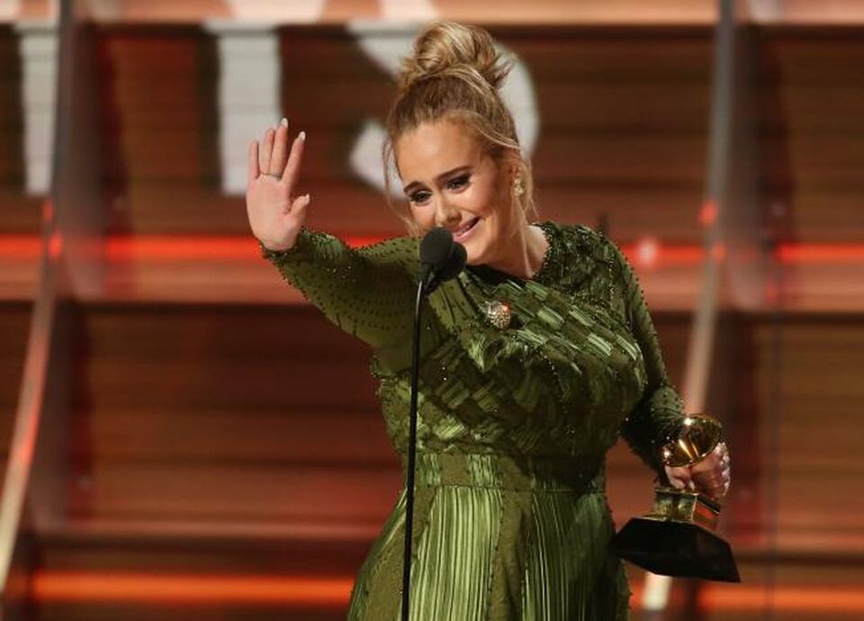 Adele waves to singer Beyonce who is in the audience as she and co-song writer Greg Kurstin (not pictured) accept the Grammy for Song of the Year for "Hello" at the 59th Annual Grammy Awards in Los Angeles, California, US, February 12, 2017. (Reuters Photo/Lucy Nicholson)