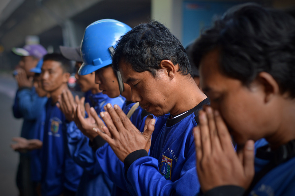 Workers pray before inspection of water tunnels along major thoroughfare on Jalan Gatot Subroto, South Jakarta, March 10, 2017. BeritaSatu Photo/Danung Arifin