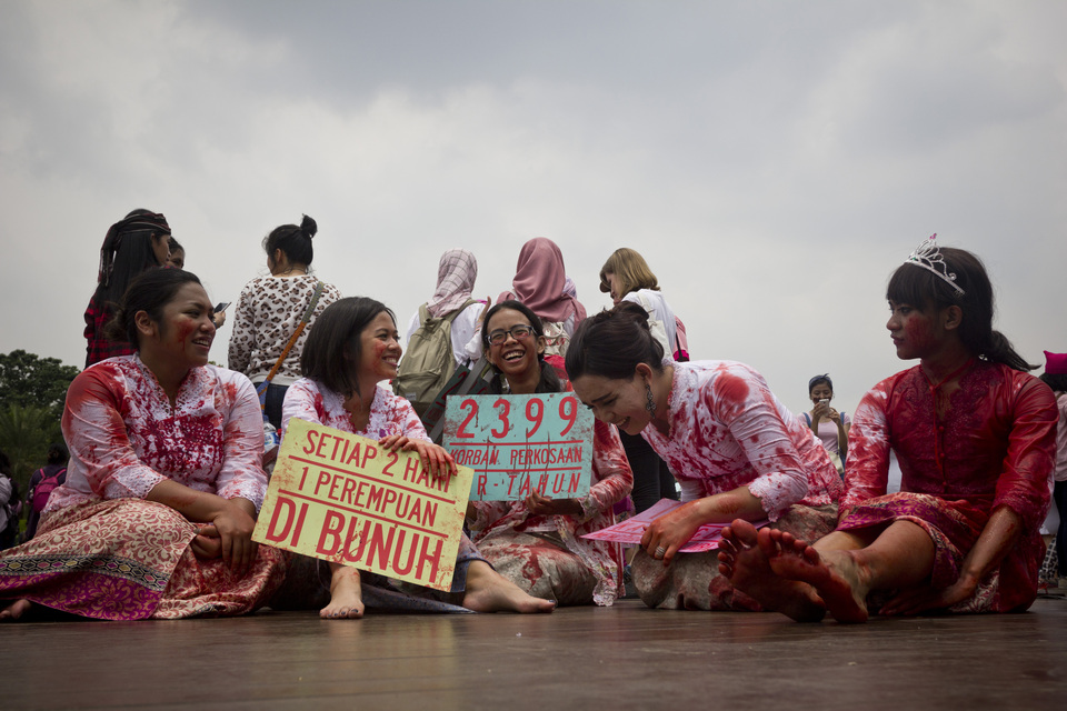 Women wear blood-stained kebayas at the National Monument, or Monas, complex in Central Jakarta during a march to protest and raise awareness about violence against women in Indonesia. (JG Photo/Yudha Baskoro) 