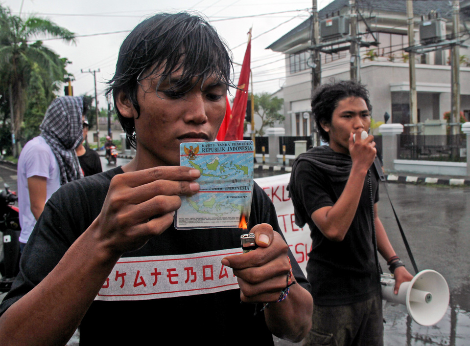 A member of the Indonesian Youth Struggle Front, or FPPI, burns an electronic ID card in Mamuju, West Sulawesi, on Monday (13/03). (Antara Photo/Akbara Tado)