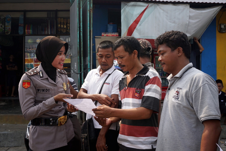 A member of the Tangerang Police facilitates a peace agreement between public transportation drivers and drivers of ride-hailing services, such as Go-Jek, Grab and Uber, in Sangiang, Banten, on Thursday (09/03). Recent clashes the between the two groups prompted the police to begin implementing peace agreements to ensure public safety. (Antara Photo/Lucky R.)