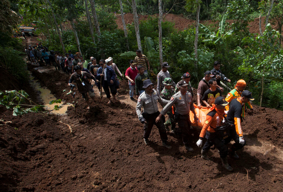 Indonesia policemen and rescuers carry the body of a victim of a landslide triggered by heavy rain at Banaran village in Ponorogo, Indonesia's East Java province, April 2, 2017.  (Reuters Photo/Sigit Pamungkas)