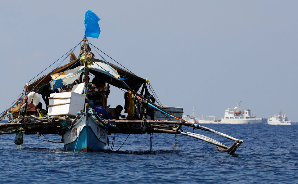 Far out in the South China Sea, where dark blue meets bright turquoise, a miles-long row of fishing boats anchor near Scarborough Shoal, backed by a small armada of coastguard projecting China's power in Asia's most disputed waters. (Reuters Photo/Erik De Castro)