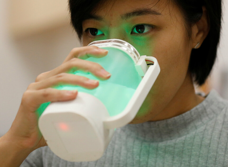 A student tastes a virtual lemonade simulator, which uses electrodes to mimic the flavor and LED lights to imitate the color of real lemonade, at the campus of the National University of Singapore on April 13. (Reuters Photo/Edgar Su)