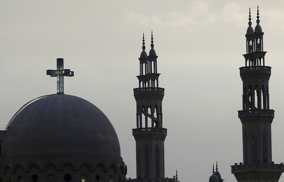 Minarets of a mosque and the cross above a church are seen at the agricultural road which leads to the capital city of Cairo, Egypt. (Reuters Photo/Amr Abdallah Dalsh)