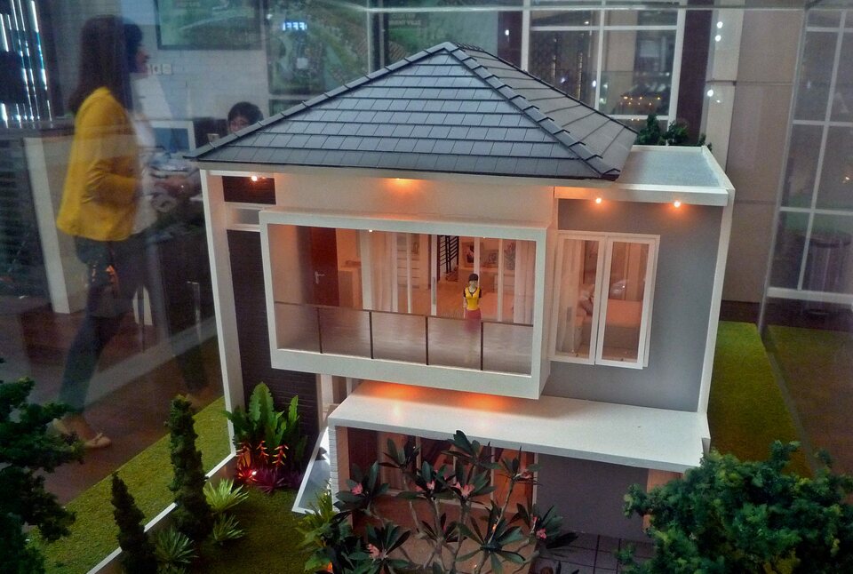 FILE - A visitor walks past a house model at a property exhibition hosted by the Real Estate Indonesia in Semarang, Central Java. (Antara Photo)