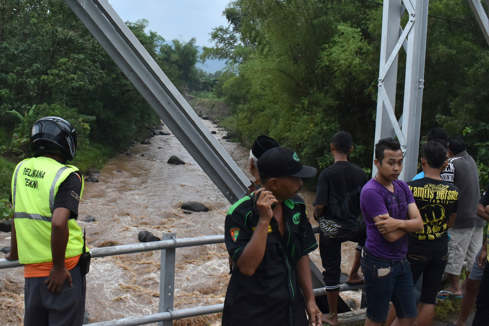 Rescuers search for six students of an Islamic boarding school in Madiun, East Java, on Monday (10/04). The children drown while trying to traverse the flooded Catur River. (Antara Photo/Siswowidodo)