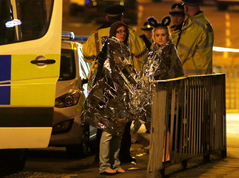 Two women wrapped in thermal blankets stand near the Manchester Arena, where United States singer Ariana Grande had been performing, in Manchester, northern England, Britain on Tuesday (23/05). (Reuters Photo/Andrew Yates)