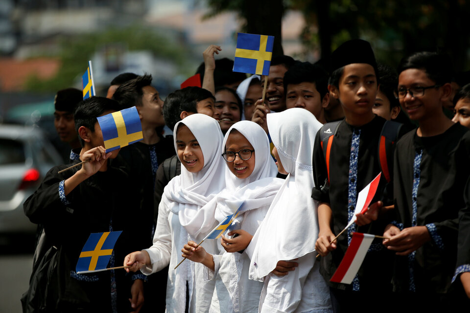 Students wait for the arrival of King Carl XVI Gustaf of Sweden and Queen Silvia in Bandung, West Java, on May 24. (Reuters Photo/Darren Whiteside)