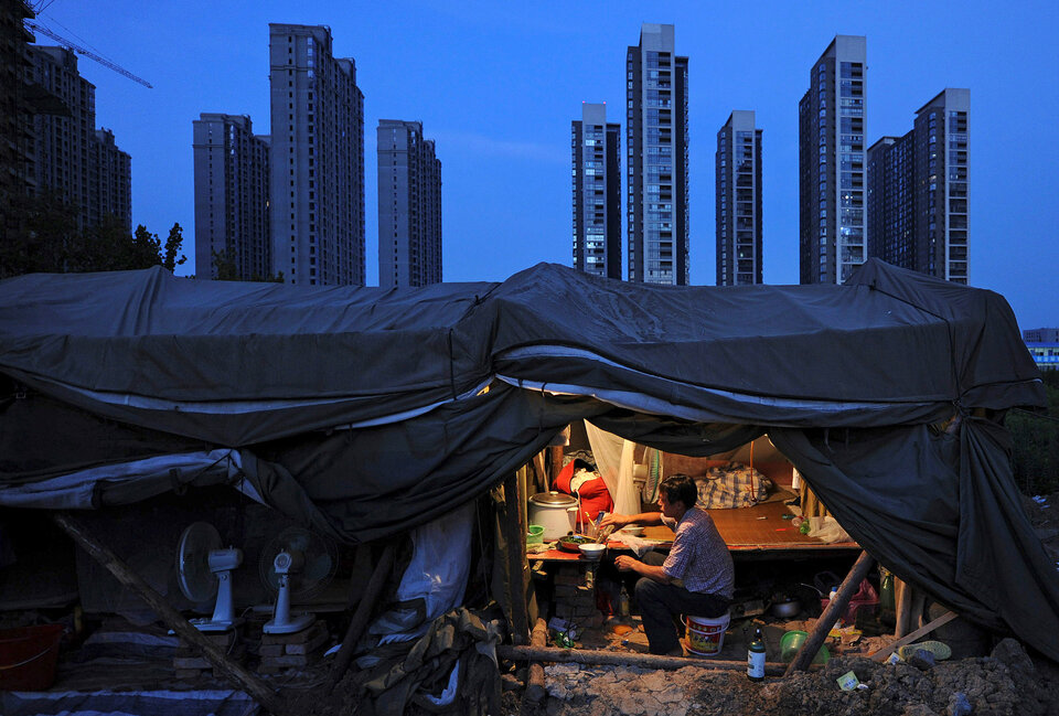 A laborer has his dinner under his shed at a construction site of a residential complex in Hefei, Anhui province, August 1, 2012.  (Reuters Photo/Stringer)