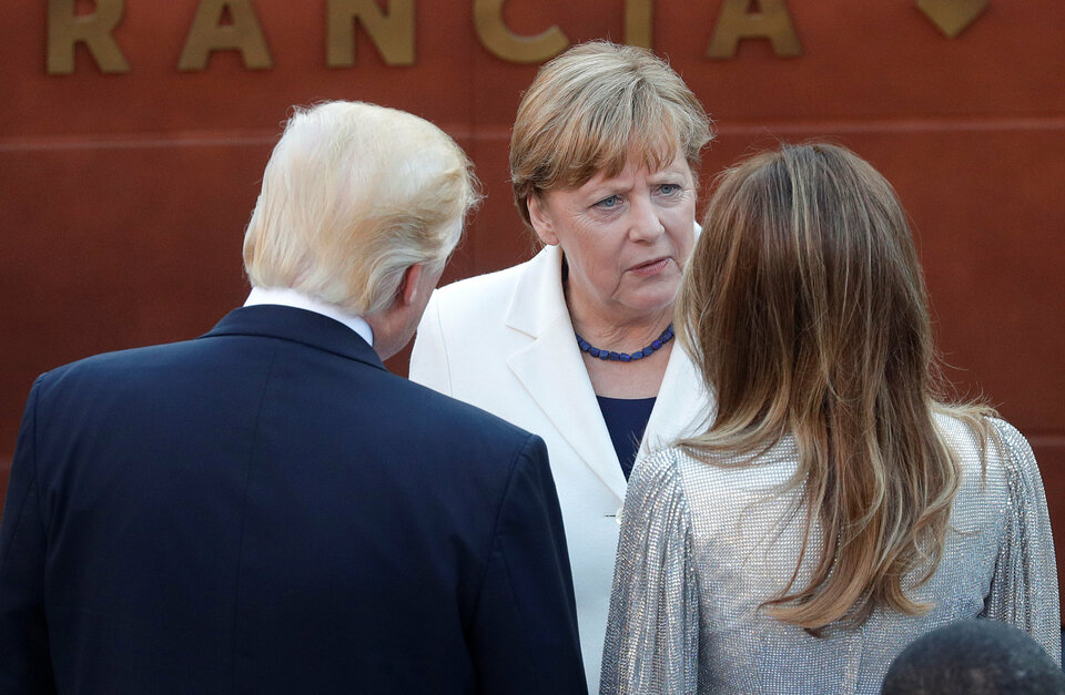 German Chancellor Angela Merkel, center, talks to United States President Donald Trump and first lady Melania Trump as they arrive to attend a performance by the La Scala Philharmonic Orchestra in the ancient Greek theater as part of the Group of  Seven summit in Taormina, Sicily, Italy on Friday (26/05). (Reuters Photo/Philippe Wojazer)