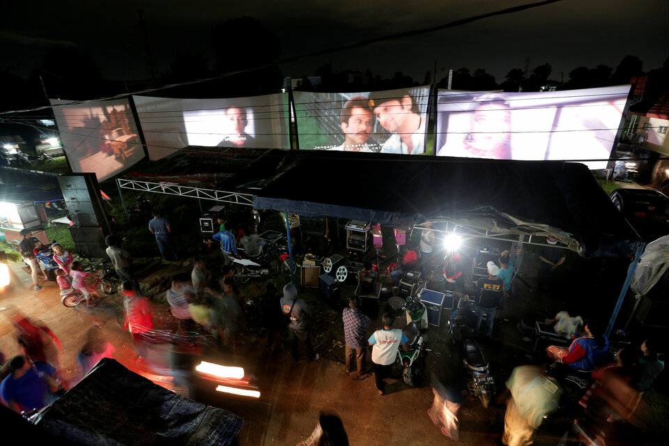 People watch films during a wedding party in Bogor, West Java. Kamaluddin, an entrepreneur from Tangerang runs a mobile cinema business, bringing movies to wedding and parties. (Reuters Photo/Beawiharta) 