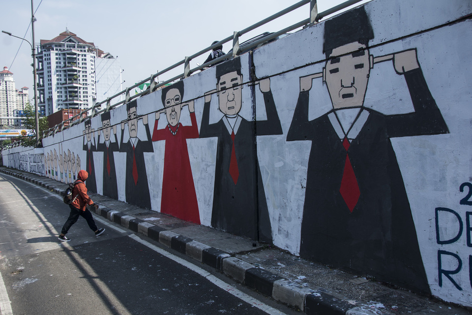 A pedestrian walks past a 'reformasi' mural near the Trisakti University campus in West Jakarta. (Antara Photo/Aprillio Akbar)