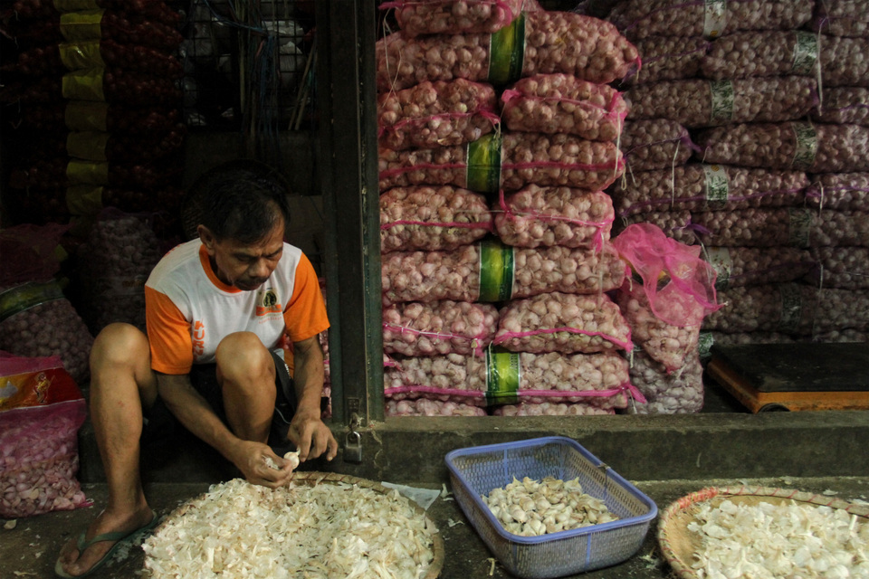 This 2020 file photo shows a man peeling garlic at the Kramat Jati market in East Jakarta. (Antara Photo/Angga Budhiyanto)