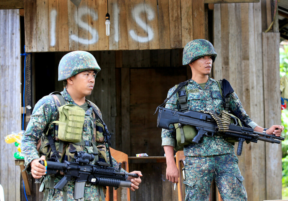 Soldiers stand guard along the main street of Mapandi village as government troops continue their assault on insurgents from the Maute group, who have taken over large parts of Marawi, Philippines on June 2, 2017.  (Reuters Photo/Romeo Ranoco)