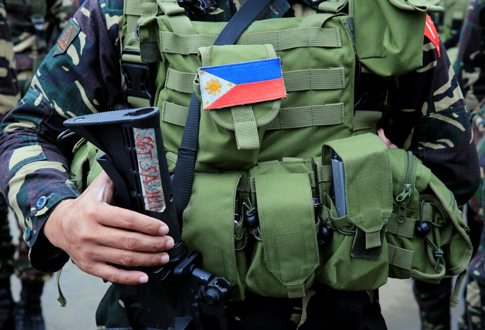 A Philippine flag is seen on a bulletproof vest of a soldier as he participates in a flag raising to mark Independence Day, as troops continue their assault against the insurgents from the Maute group who has taken over large parts of the city, in Marawi City, Philippines on Monday (12/06). (Reuters Photo/Romeo Ranoco)
