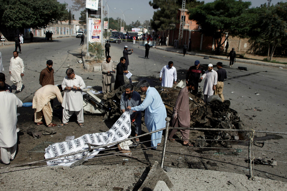 Police and rescue officials cover a body after a blast in Quetta. (Reuters Photo/Naseer Ahmed)
