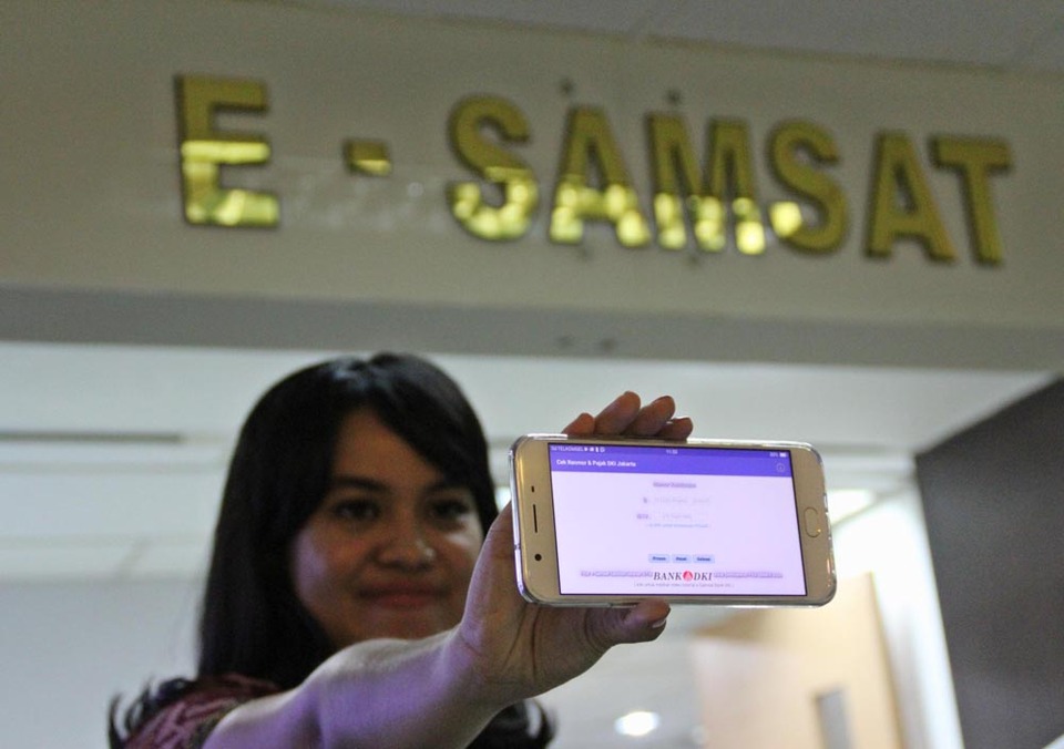 Officer showed E-Samsat Application in the event of inauguration of Data & Tax Information Service of Motor Vehicle in Jakarta, June 21, 2017. E-Samsat is the result of Bank DKI cooperation with Jakarta Regional Metropolitan Police in making new queue system in One Roof Service Building (PSA) , As well as less cash services by providing counters of Bank DKI non-cash transactions.
This application allows people to know the value of vehicle taxes that must be paid, and also can reduce the number of taxpayers taxpayer. So it can help the DKI Jakarta government in increasing local revenue from vehicle tax. Courtesy photo of Bank DKI