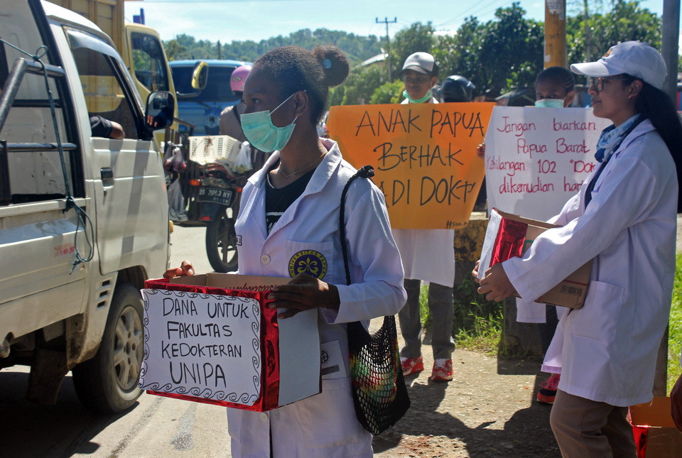Medical students of the Papua State University (Unipa) participating in a peaceful rally and fund-raising event at a traffic light in Sorong, West Papua, on Wednesday (07/06). The more than 100 medical students were protesting the discontinuation of medical study program that was a collaboration between the University of Indonesia, Unipa and the Sorong district government. (Antara Photo/Olha Mulalinda)